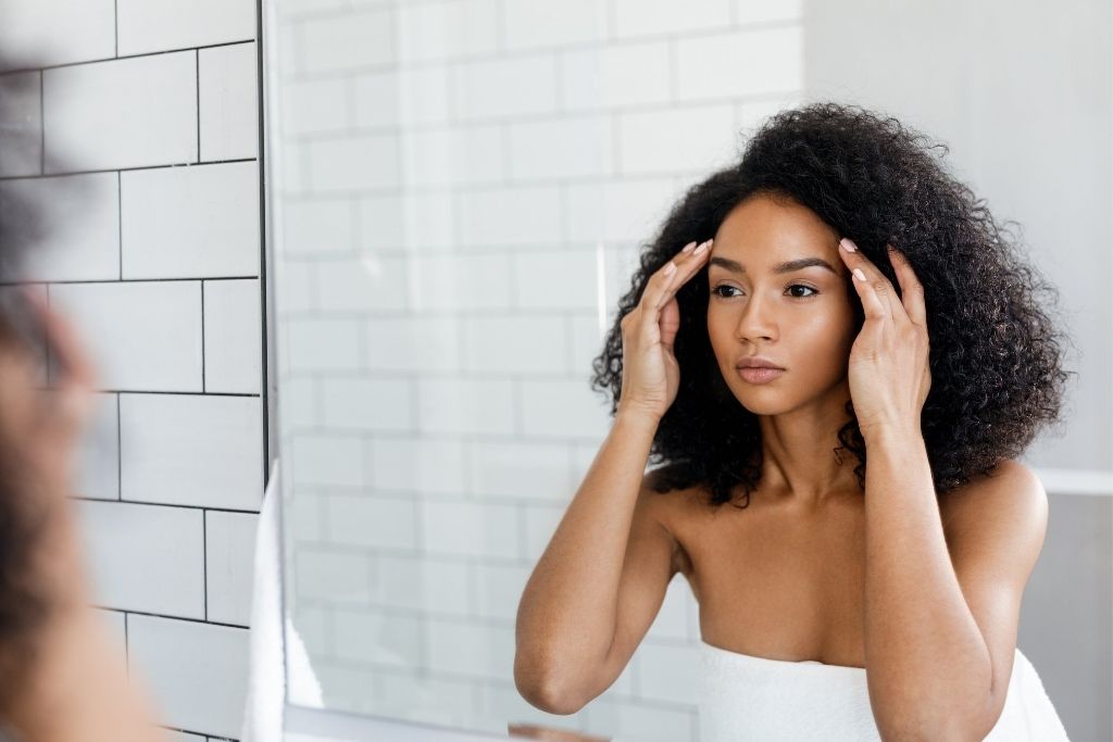 Woman looking in mirror at face